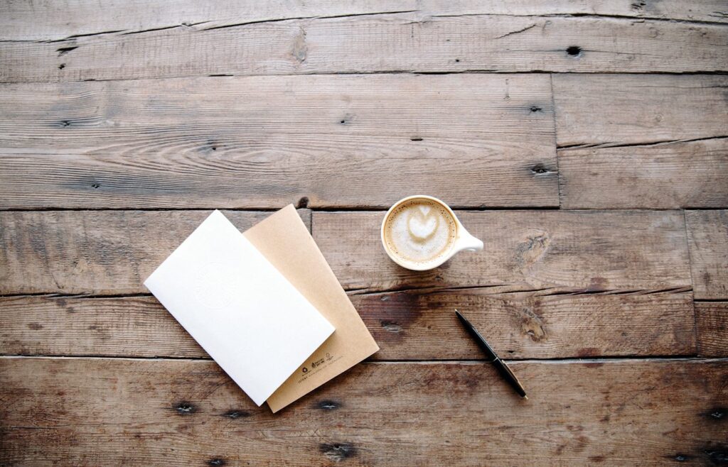 Carnet et stylo posés sur une table en bois